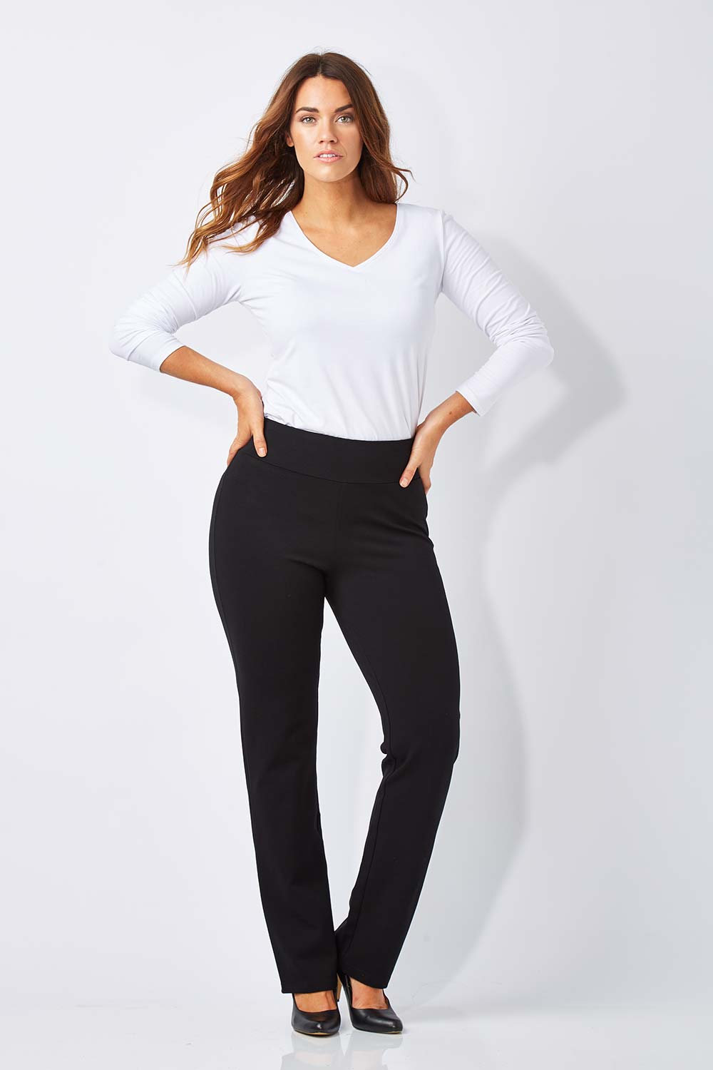 Model Laura wearing size M of The Slimming Trouser Leg Pant in colour Black (Black), from the front, showing the whole outfit