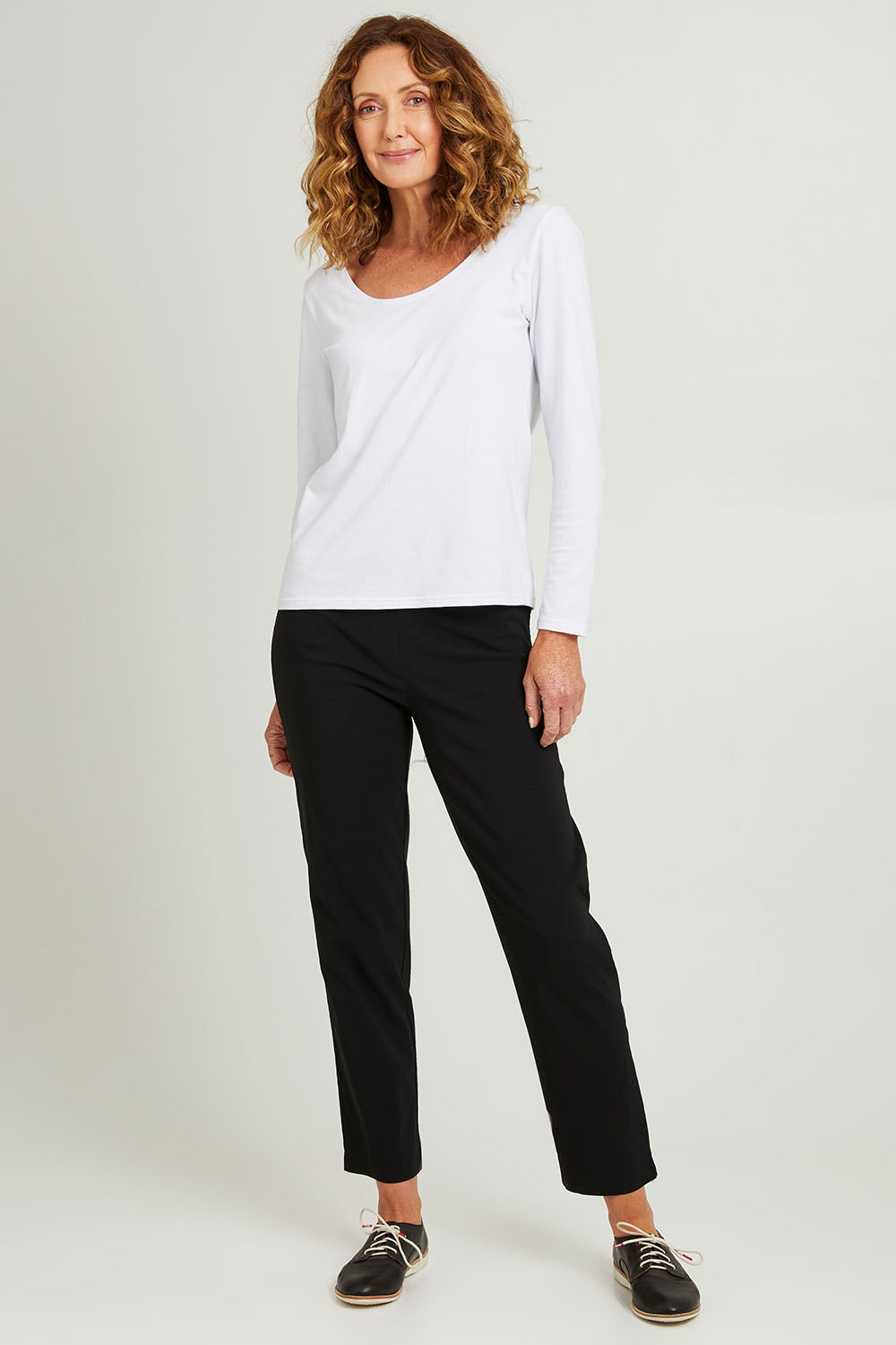 Model Emma wearing size S of the Pull On Pant in colour Black (Black), from the front, showing the whole outfit