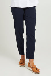 Model Emma wearing size S of the Pull On Pant in colour Navy (Blue), from the front, cropped image
