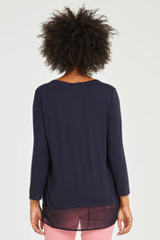 Model Olivia wearing size S of the L/S Georgette Hem Top in colour Navy (Blue), from the back
