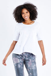 Model Schanez wearing size S of the Short Sleeved Tee in colour White (White), from the front, cropped image