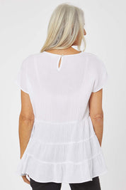 Model Rachel wearing size S of the Tiered Tunic in colour White (White), from the back