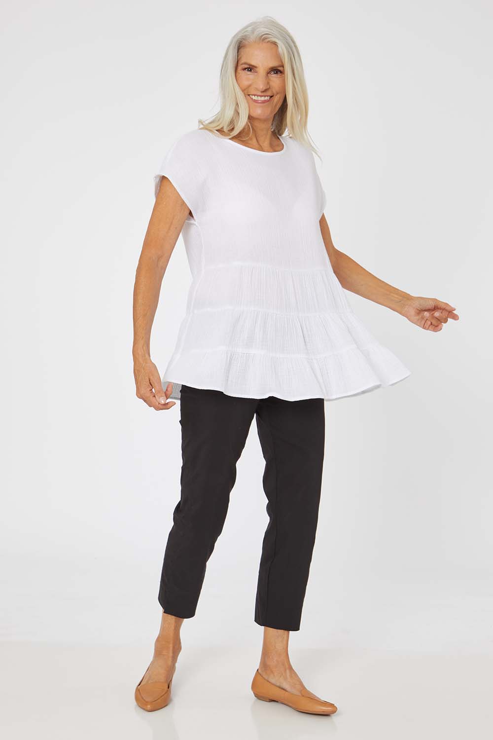 Model Rachel wearing size S of the Tiered Tunic in colour White (White), from the front, showing the whole outfit