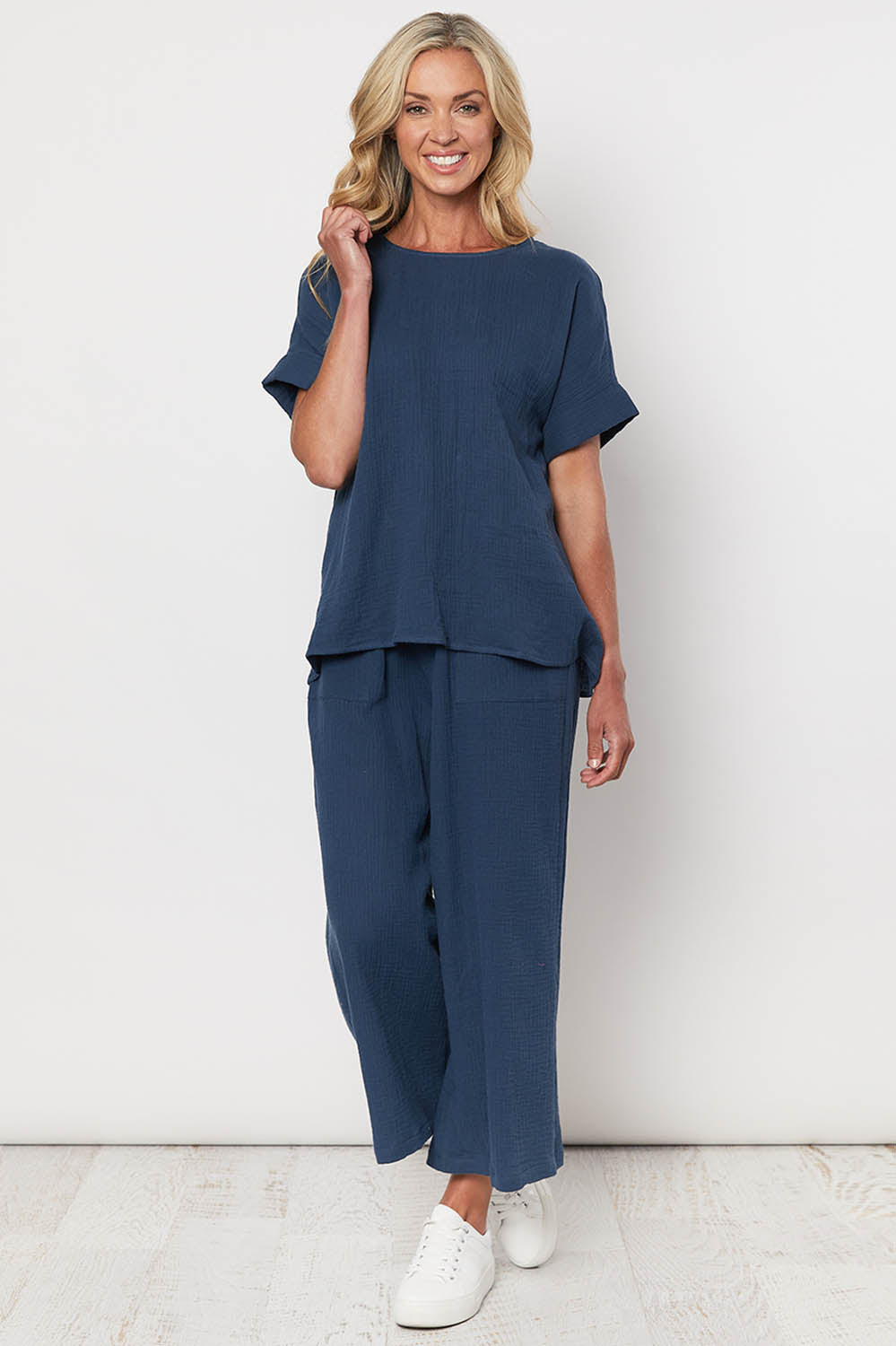 A model wearing the Cotton Pant in colour Navy (Blue), from the front, showing the whole outfit