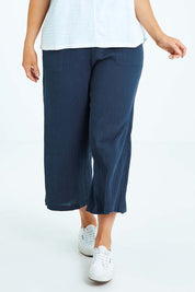 Model Laura wearing size L of the Cotton Pant in colour Navy (Blue), from the front, cropped image