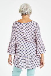Model Elise wearing size S of the Ruffle Hem Spot Top in colour Pink (Pink), from the back