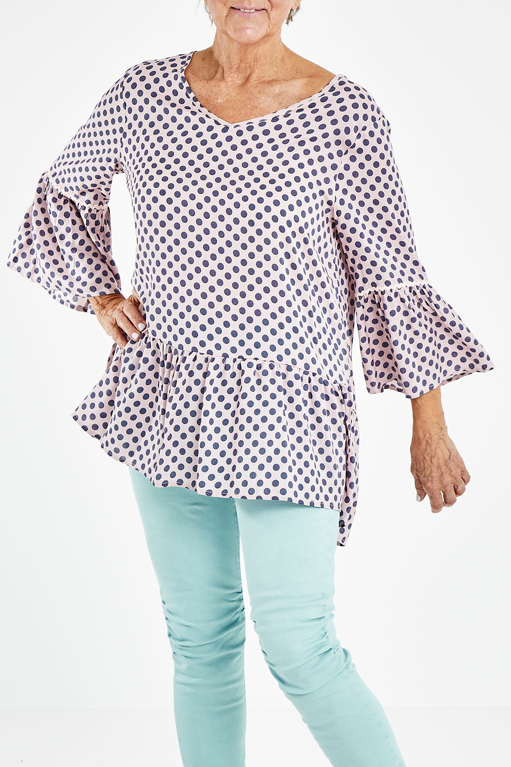 Model Elise wearing size S of the Ruffle Hem Spot Top in colour Pink (Pink), from the front, cropped image