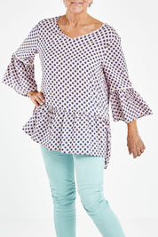 Model Elise wearing size S of the Ruffle Hem Spot Top in colour Pink (Pink), from the front, cropped image