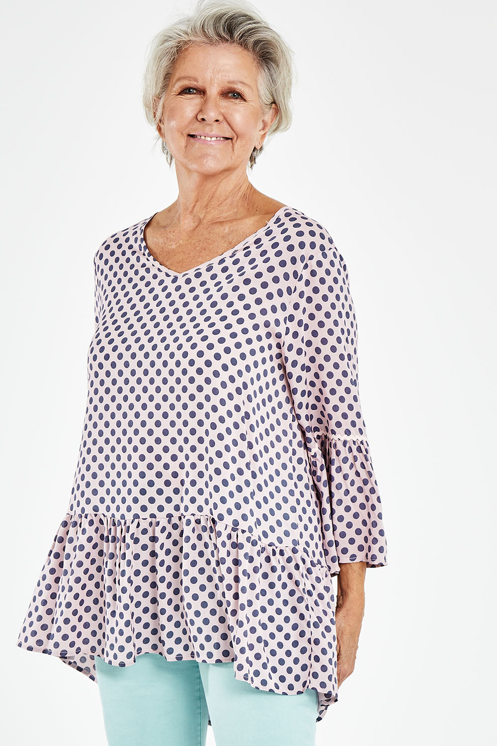 Model Elise wearing size S of the Ruffle Hem Spot Top in colour Pink (Pink), from the front, cropped image