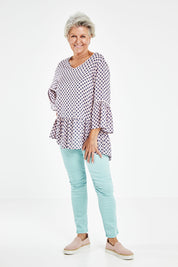 Model Elise wearing size S of the Ruffle Hem Spot Top in colour Pink (Pink), from the front, showing the whole outfit