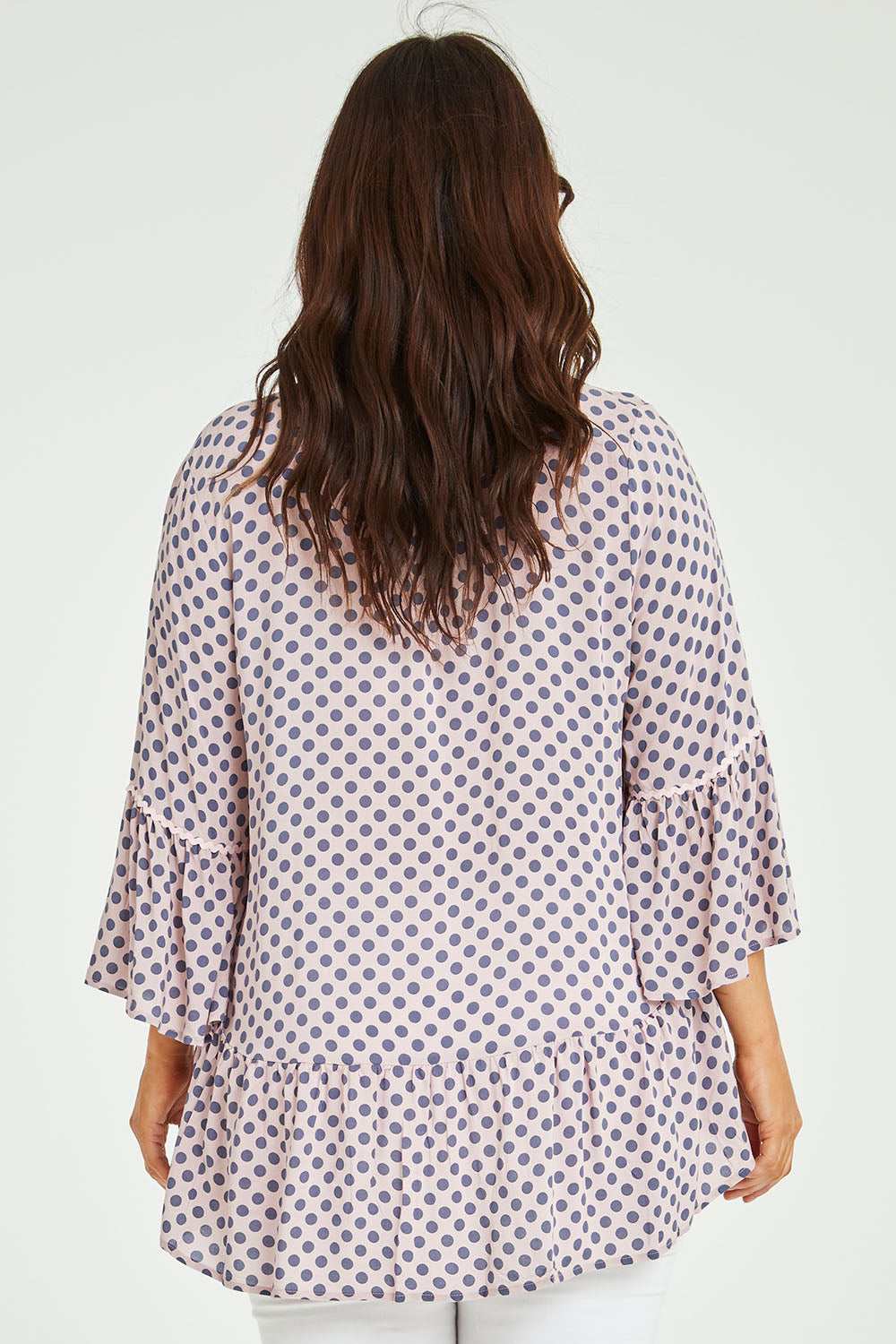 Model Laura wearing size L of the Ruffle Hem Spot Top in colour Pink (Pink), from the back
