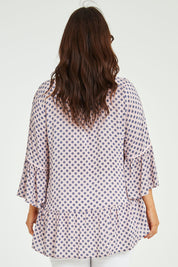Model Laura wearing size L of the Ruffle Hem Spot Top in colour Pink (Pink), from the back