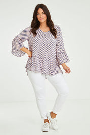 Model Laura wearing size L of the Ruffle Hem Spot Top in colour Pink (Pink), from the front, showing the whole outfit