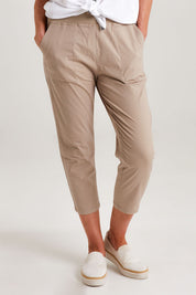 Model Emma wearing size S of the Santorini Cotton Pant in colour Natural, from the front, cropped image