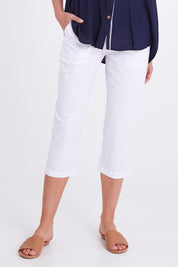 Model Madeline wearing size S of the Santorini Cotton Pant in colour White (White), from the front, cropped image