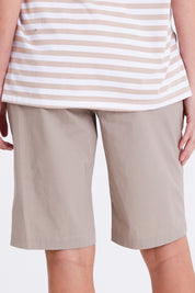 Model Madeline wearing size S of the Santorini Cotton Short in colour Sand, from the back