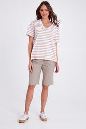 Model Madeline wearing size S of the Santorini Cotton Short in colour Sand, from the front, showing the whole outfit
