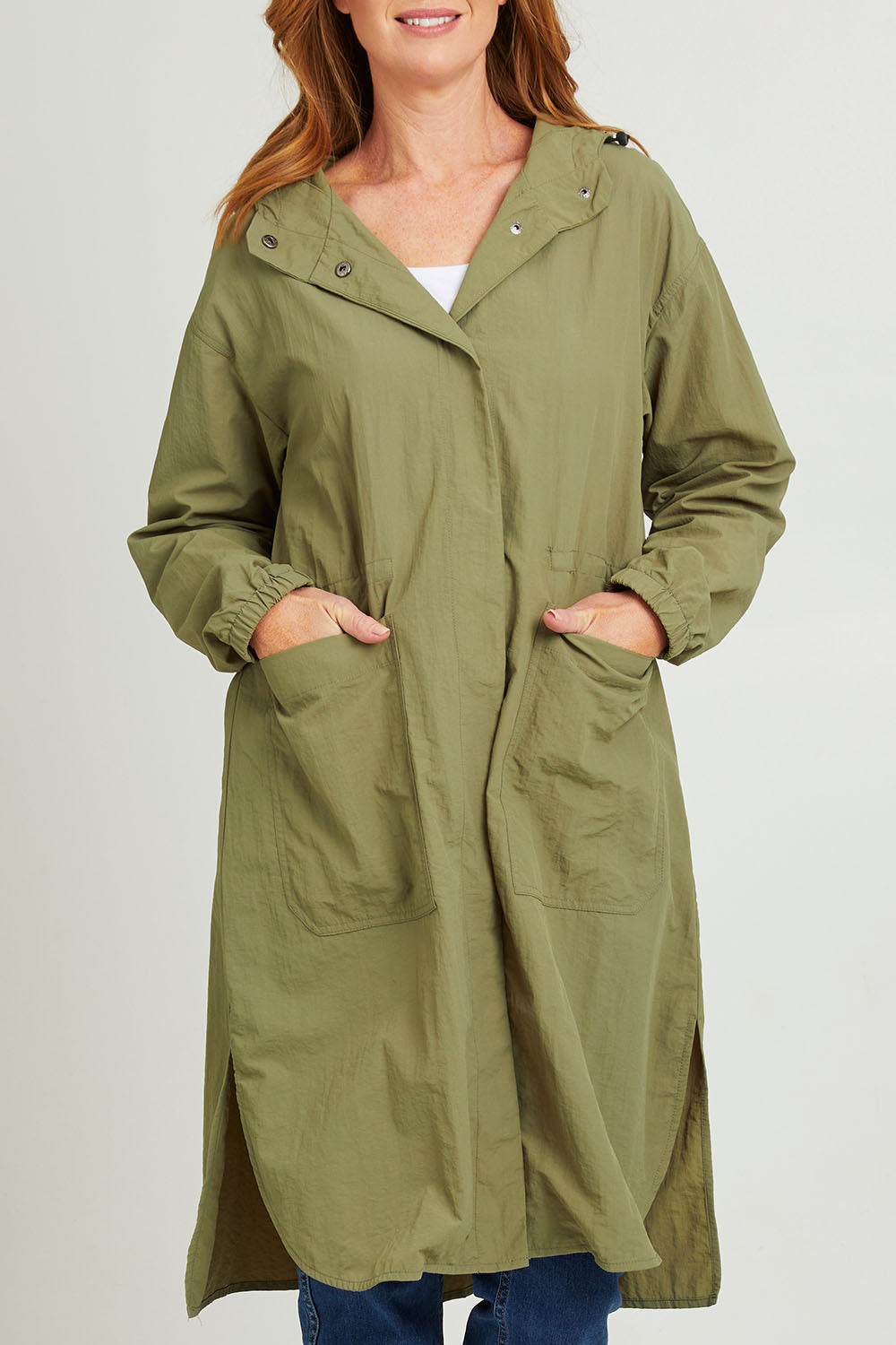Model Katie wearing size S of the Long Travel Jacket in colour Khaki (Green), from the front, cropped image
