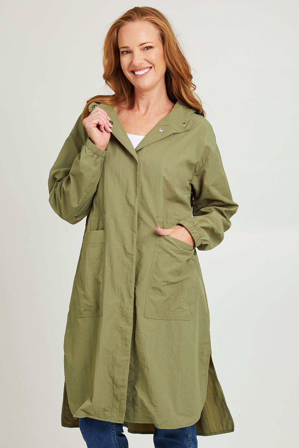 Model Katie wearing size S of the Long Travel Jacket in colour Khaki (Green), from the front, cropped image