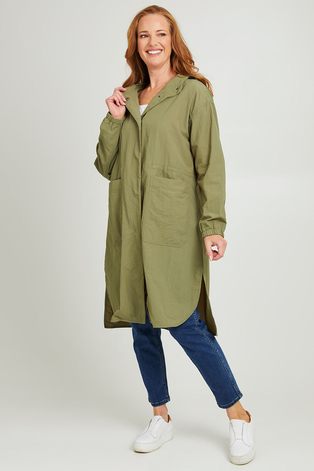 Model Katie wearing size S of the Long Travel Jacket in colour Khaki (Green), from the front, showing the whole outfit