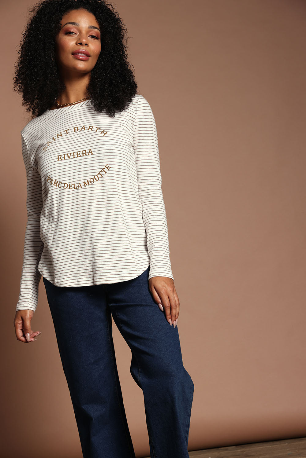 Model Ziara wearing size S of the Riviera Cotton Blend Tee in colour Natural, from the front, showing the whole outfit