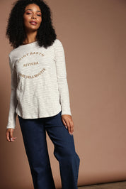 Model Ziara wearing size S of the Riviera Cotton Blend Tee in colour Natural, from the front, showing the whole outfit