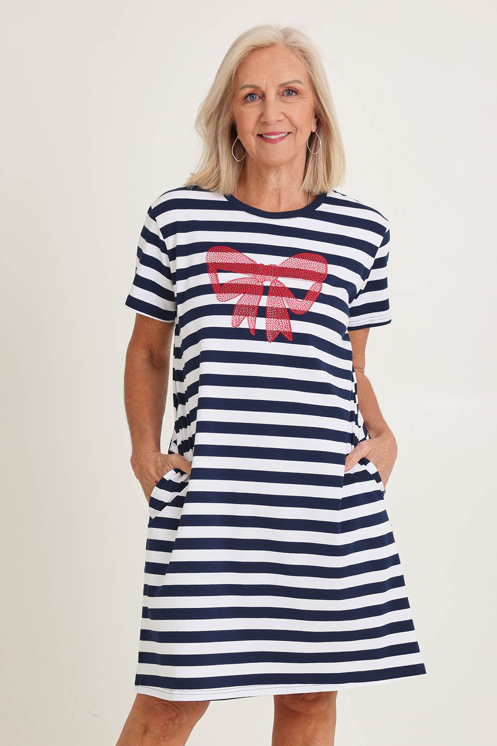 Model Sandy wearing size S of the Red Bow Stripe Cotton Dress in colour Navy (Blue), from the front, cropped image