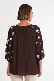Model Riinar wearing size 10 of the Canopy Embroidered Top – Coffee in colour Coffee, from the back
