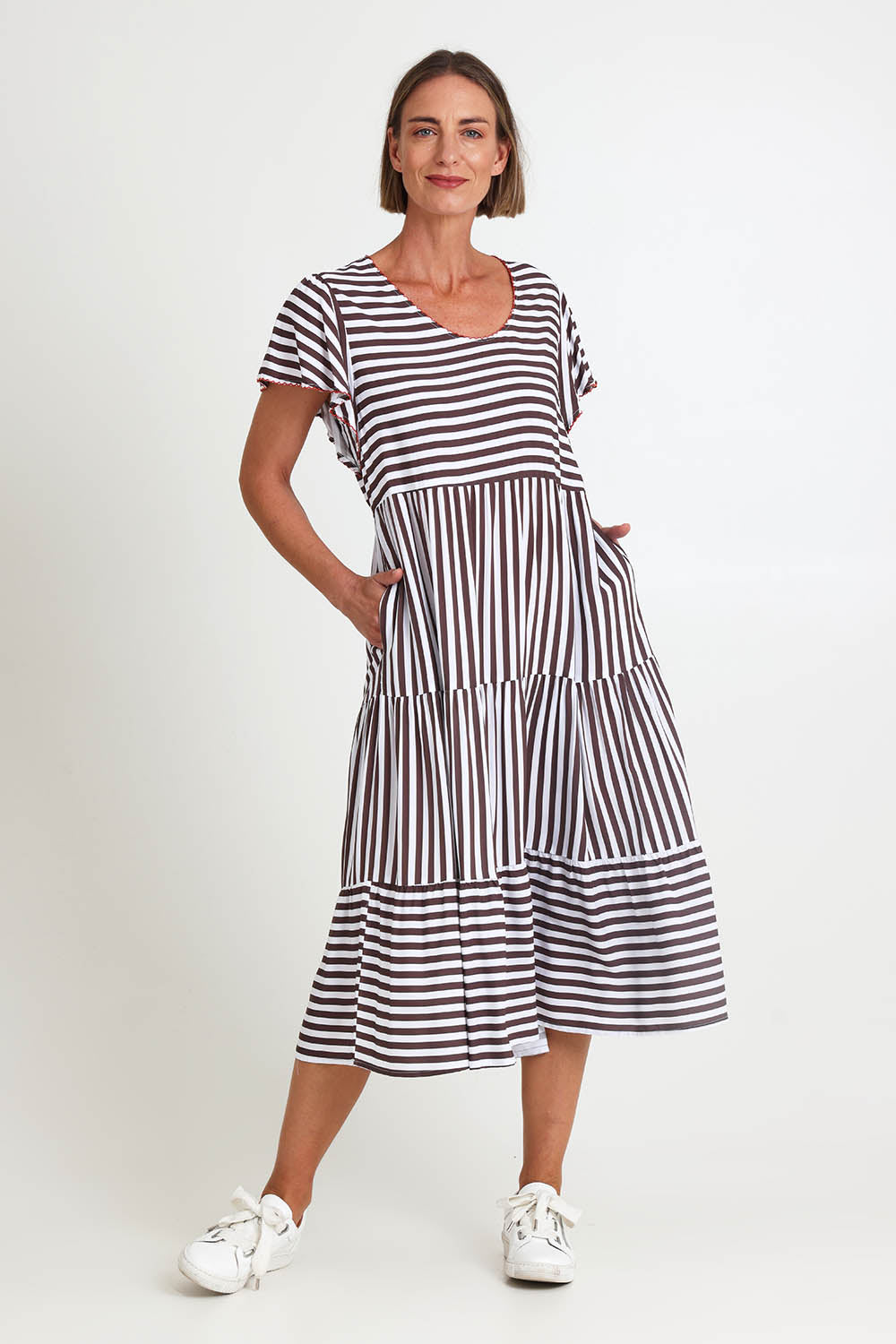 Model Riinar wearing size 10 of the Kalahari Stripe Dress – Coffee in colour Coffee, from the front