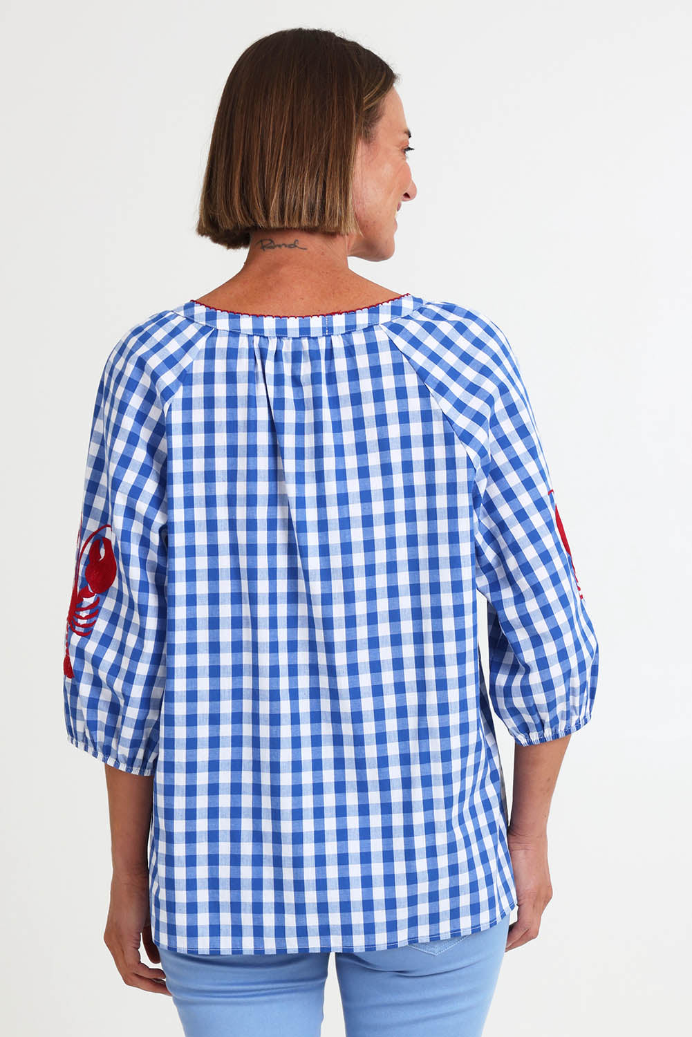 Model Riinar wearing size 10 of the Cove Check Top – Azure in colour Azure, from the back