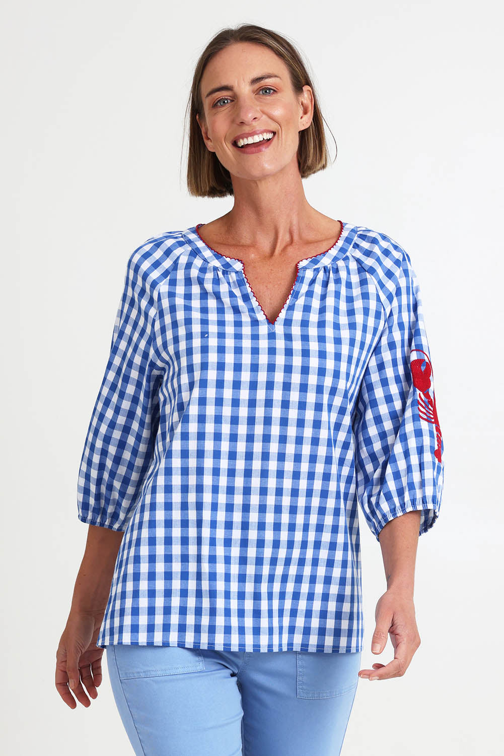 Model Riinar wearing size 10 of the Cove Check Top – Azure in colour Azure, in a cropped view
