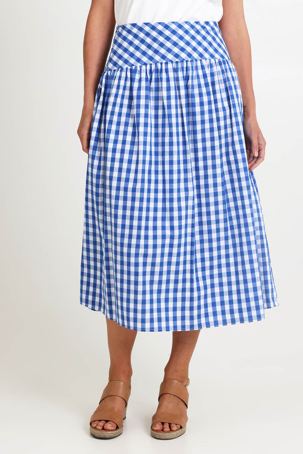 Model Riinar wearing size 10 of the Amalfi Check Skirt – Azure in colour Azure, in a cropped view
