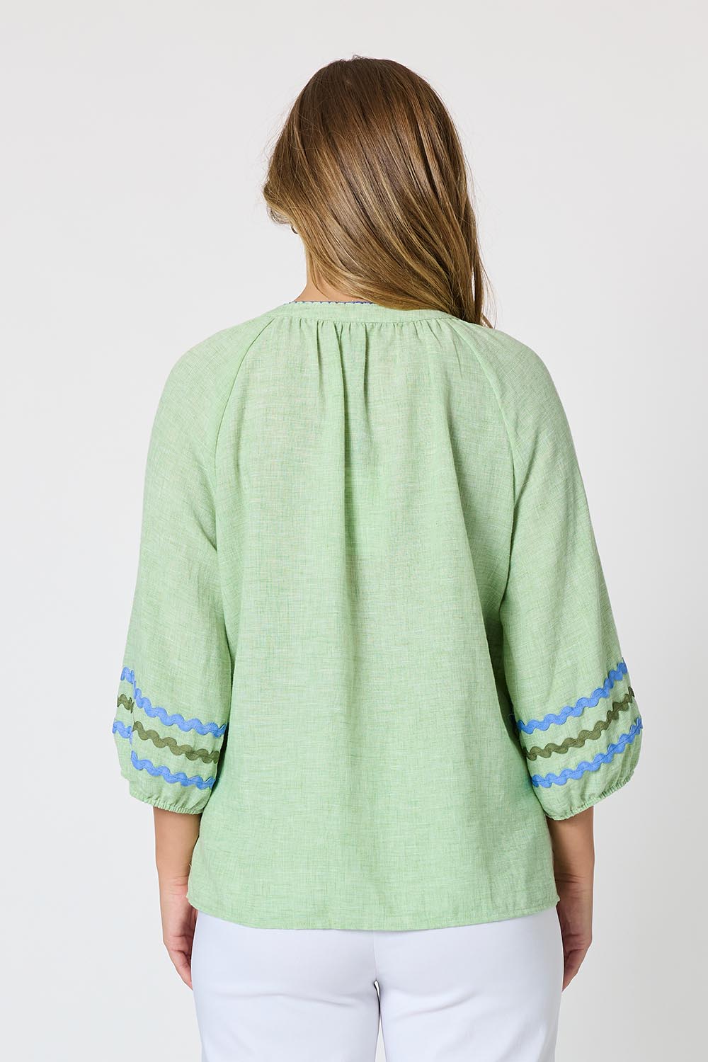Model Genericm wearing size sample of the Canopy Ric Rac Top - Apple in colour Apple, from the back