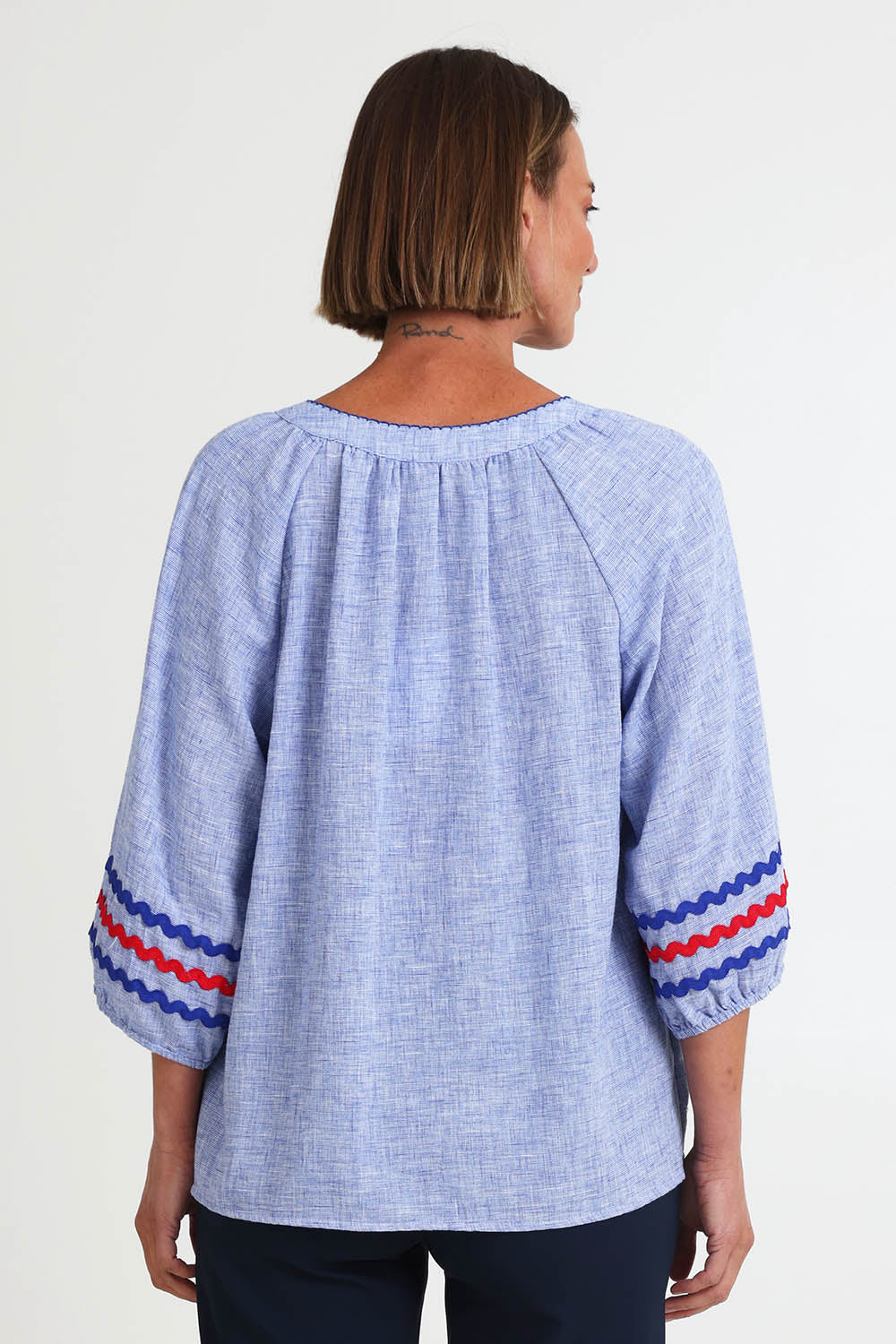 Model Riinar wearing size 10 of the Canopy Ric Rac Top – Chambray in colour Chambray, from the back