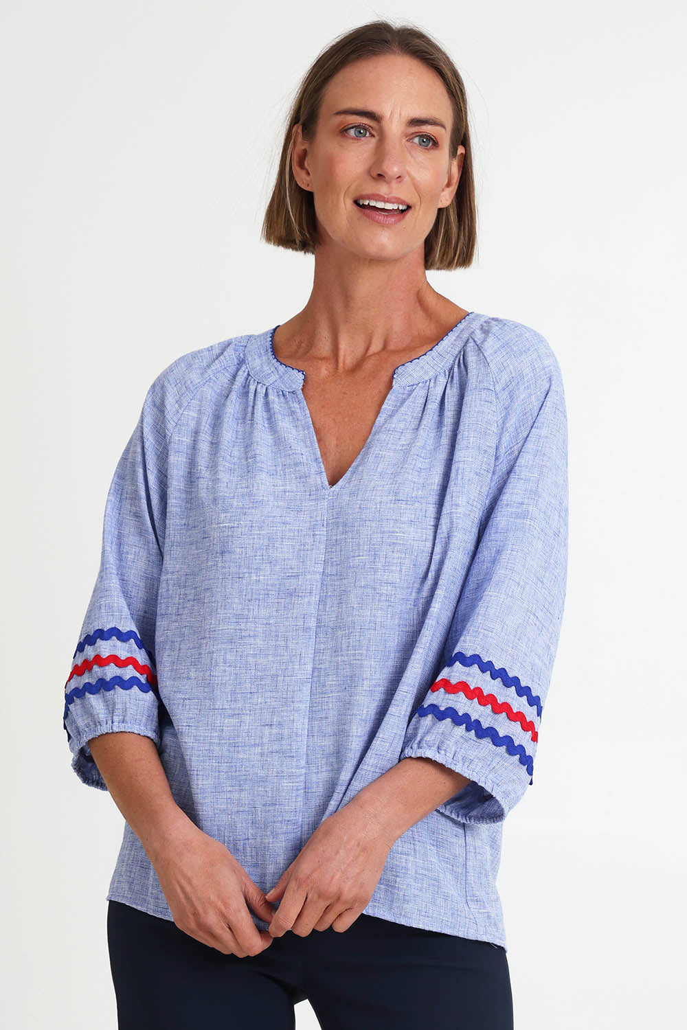 Model Riinar wearing size 10 of the Canopy Ric Rac Top – Chambray in colour Chambray, in a cropped view