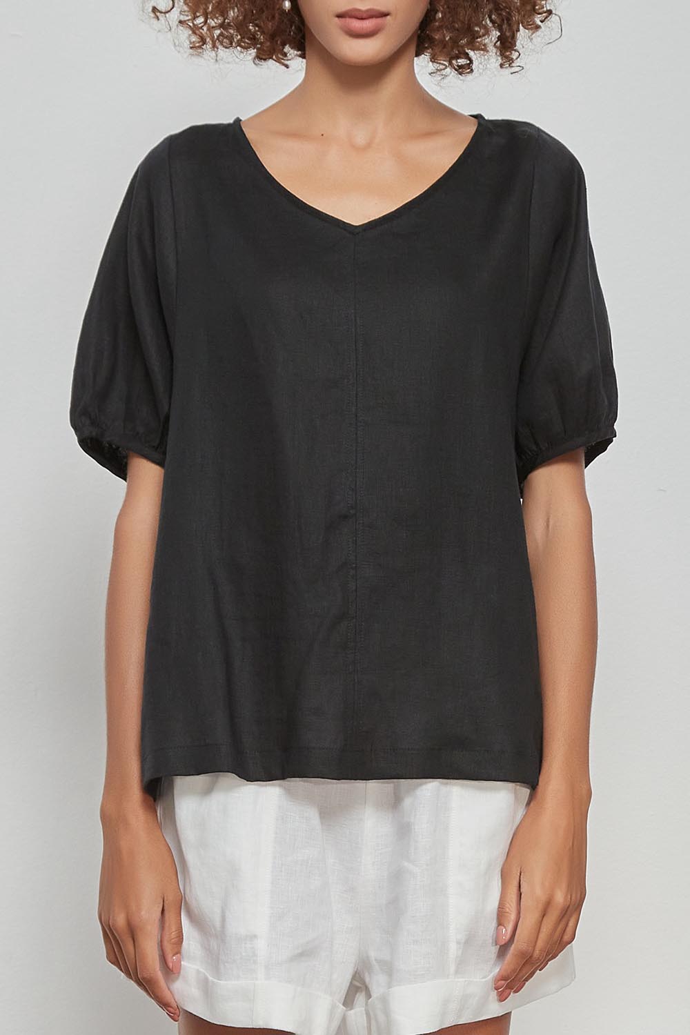 A model wearing the Bishop Sleeve Tee in colour Black (Black), from the front, cropped image