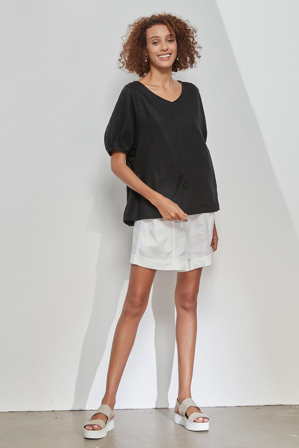 A model wearing the Bishop Sleeve Tee in colour Black (Black), from the front, showing the whole outfit