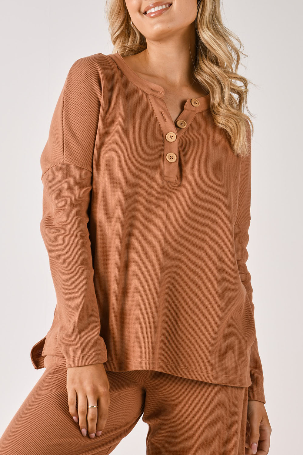 A model wearing the Waffle Jersey 1/2 Placket Top in colour Mocha, from the front, cropped image