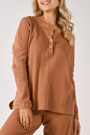 A model wearing the Waffle Jersey 1/2 Placket Top in colour Mocha, from the front, cropped image
