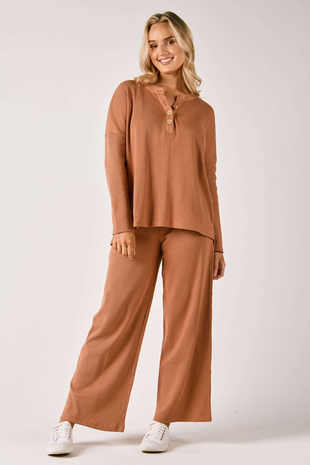 A model wearing the Waffle Jersey 1/2 Placket Top in colour Mocha, from the front, showing the whole outfit