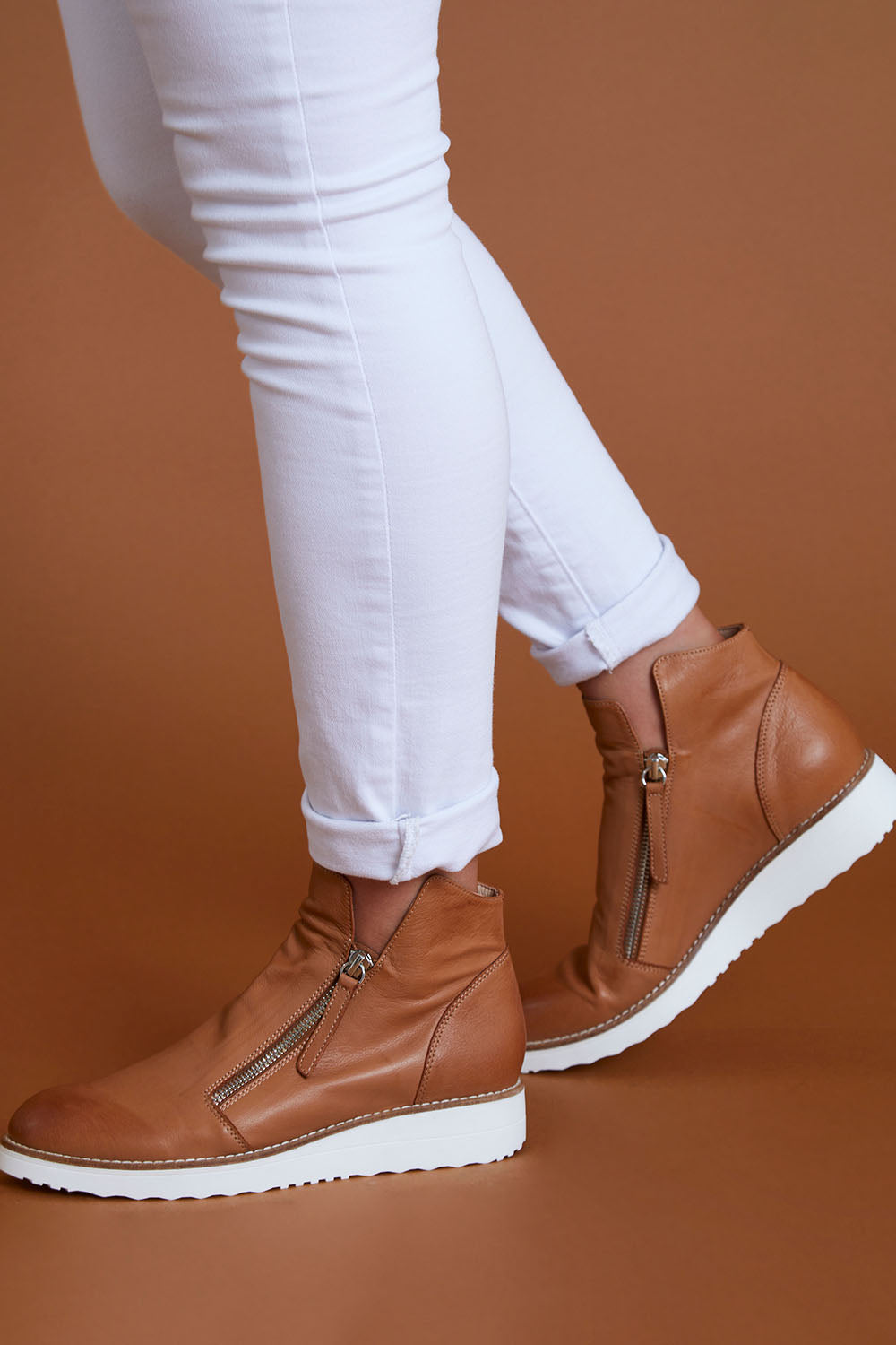A model wearing size 40 of the Ohmy Ankle Boot in colour DkTanWhite, from the front, cropped image