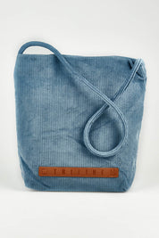 A model wearing the Corduroy Tote Bag in colour Blue (Blue), from the front, showing the whole outfit