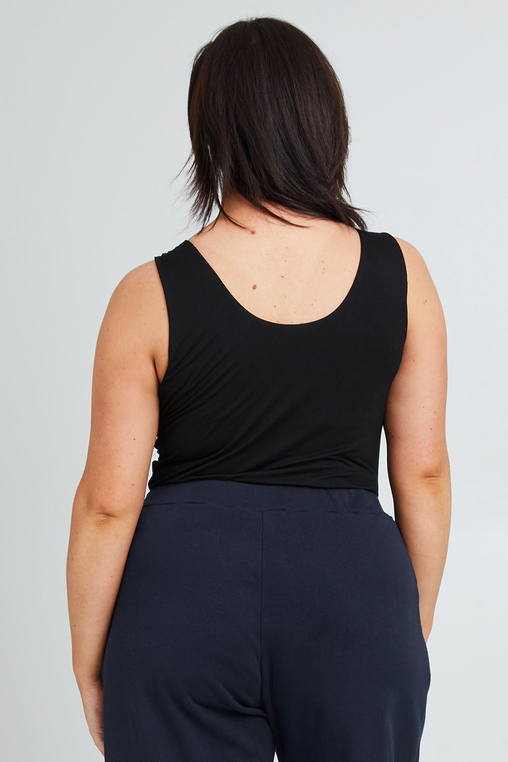 Model Poppy wearing the Modal Shelf Bra Tank in colour Black (Black), from the back