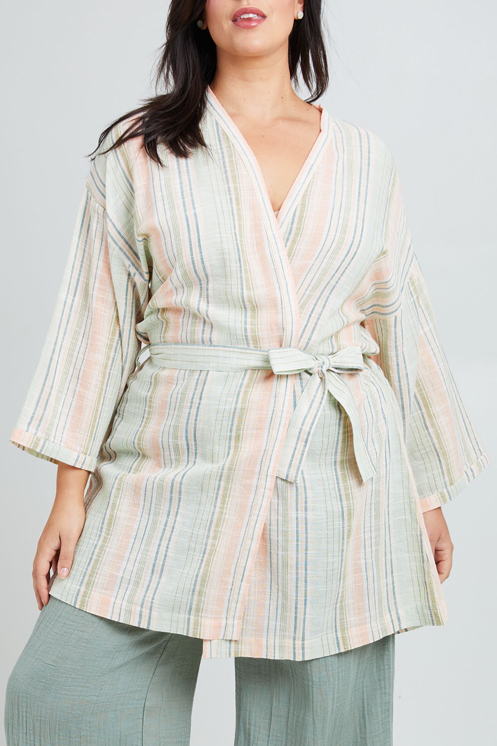 Model Poppy wearing the Cotton Stripe Dressing Robe in colour Softstripe (Green), from the front, cropped image