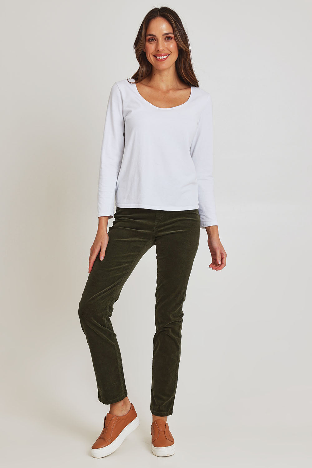 Model Madeline wearing size 10 of the Pin Cord Slim Pant in colour Deepsage (Green), from the front, showing the whole outfit