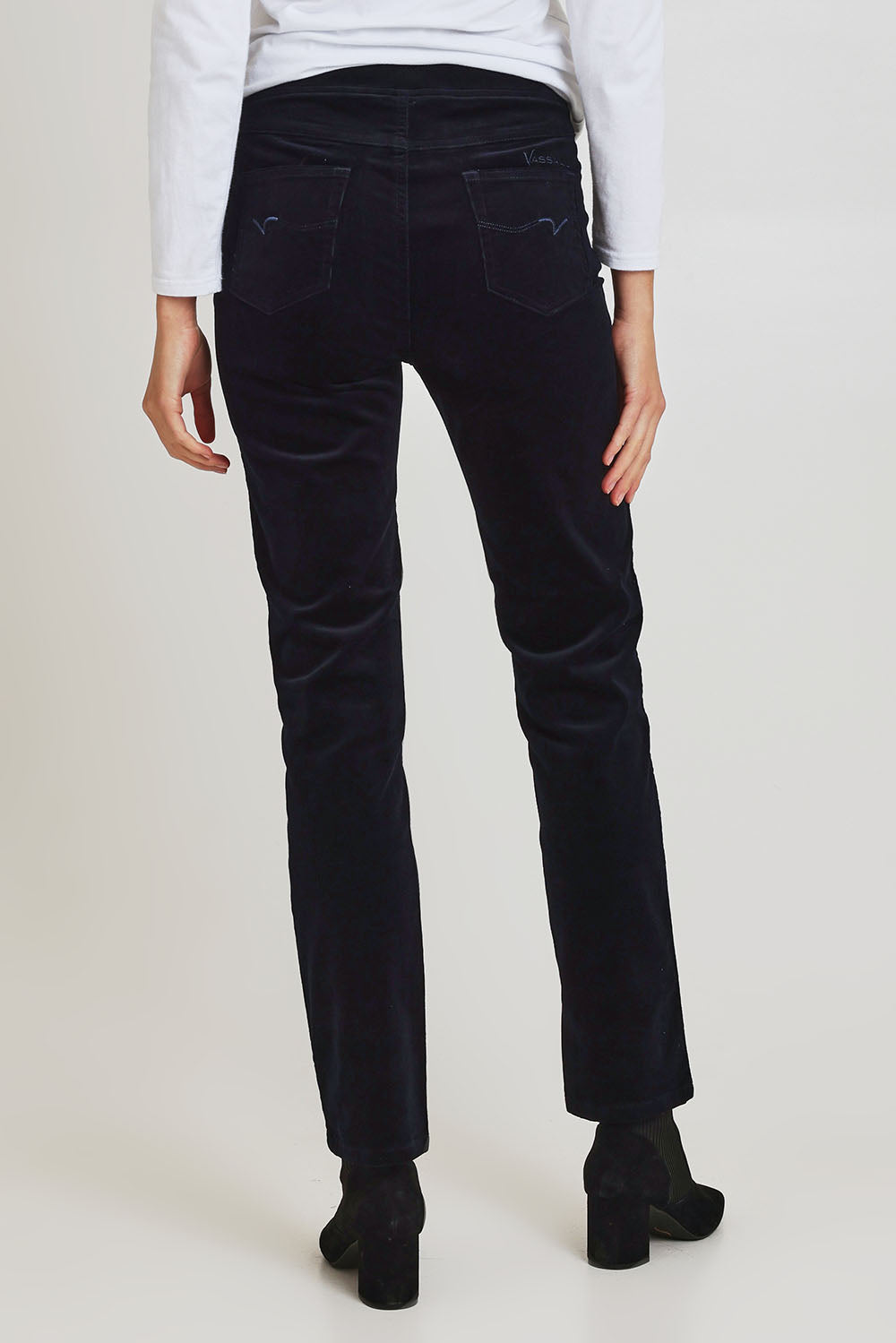 Model Madeline wearing size 10 of the Pin Cord Slim Pant in colour Midnight (Blue), from the back