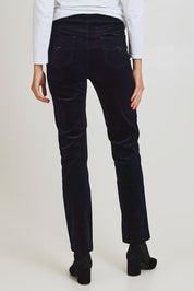 Model Madeline wearing size 10 of the Pin Cord Slim Pant in colour Midnight (Blue), from the back