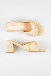 Model Genericm wearing size sample of the Stella Block Heel Mule - Naturalraffia in colour Naturalraffia, from an angle