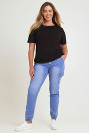 Model Chanel wearing size 16 of the Harlow Cargo Jogger in colour Middenim (Blue), from the front, showing the whole outfit