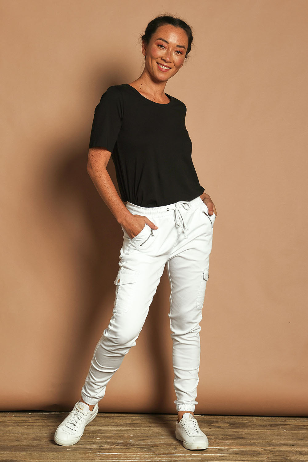 Model Katie wearing size 10 of the Harlow Cargo Jogger in colour White (White), from the front, showing the whole outfit
